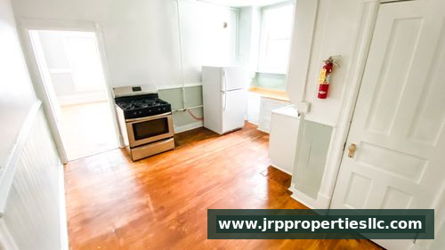 Kitchen with hardwood floors, oven, refrigerator, and natural light